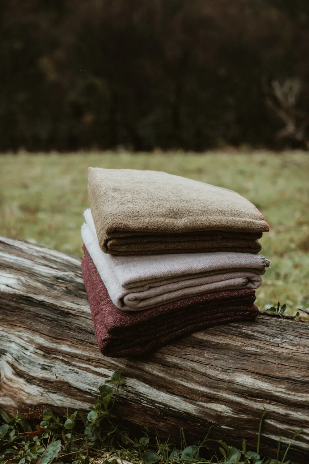 A stack of folded blankets in muted colours.