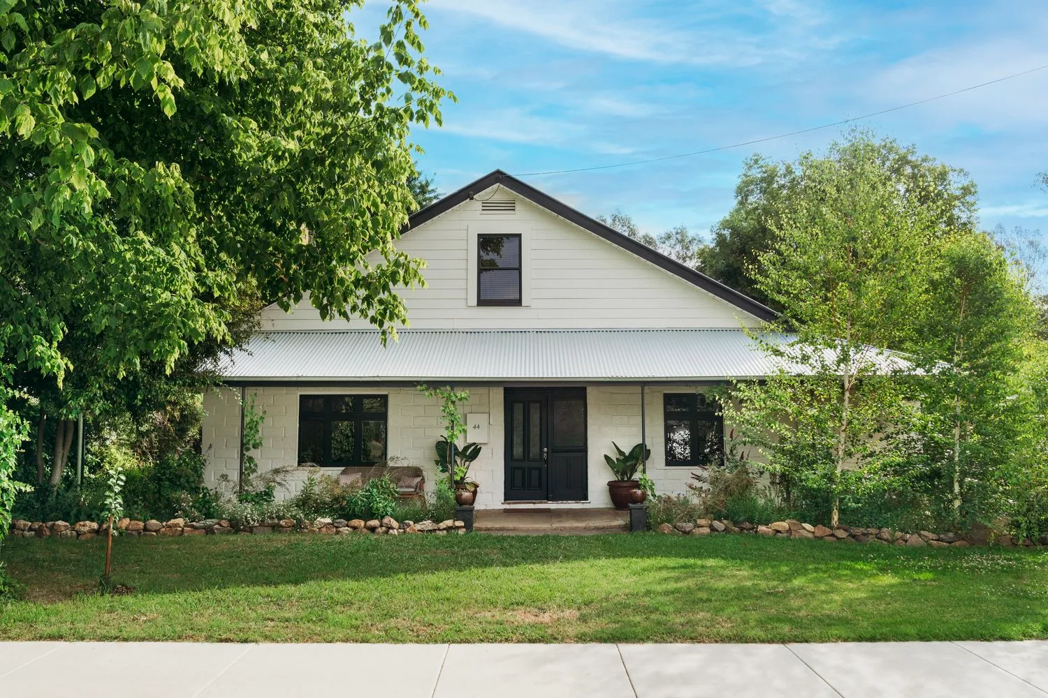 The pale façade of the Wangaratta house behind trees.