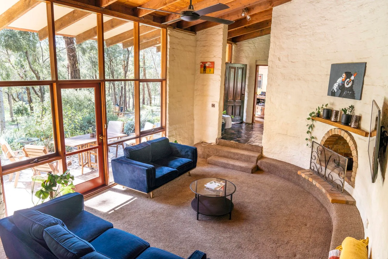 A living room with timber ceilings and large windows.