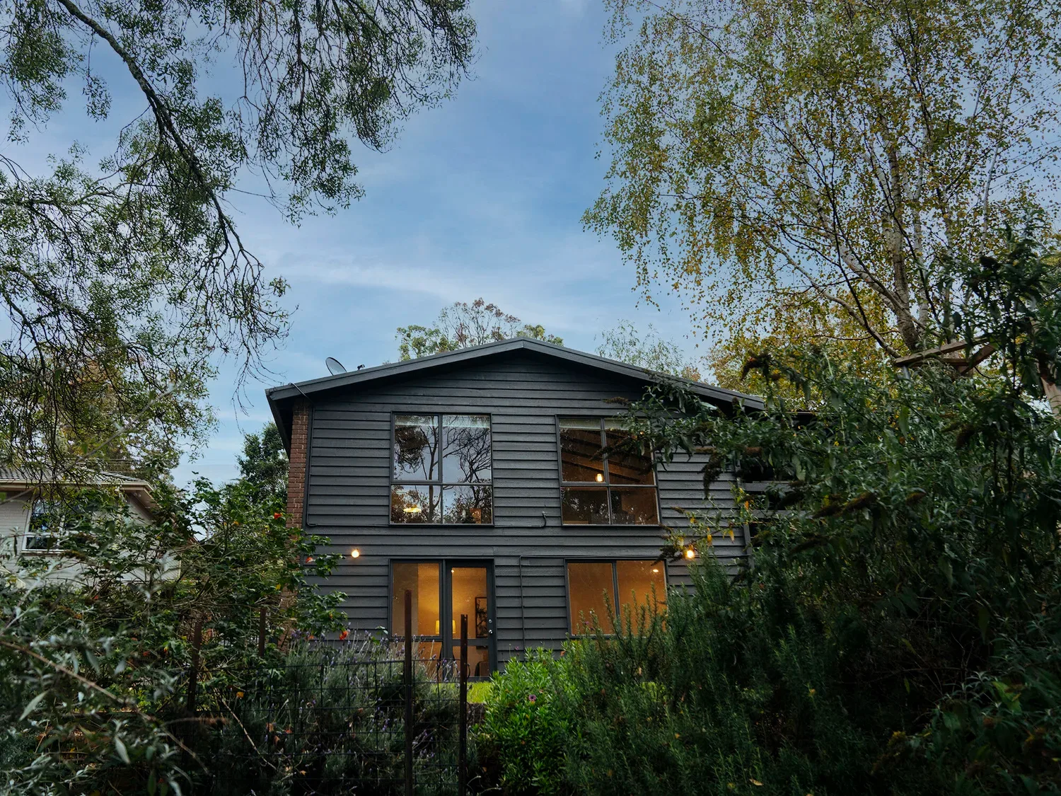 The dark-clad Emerald house among trees.