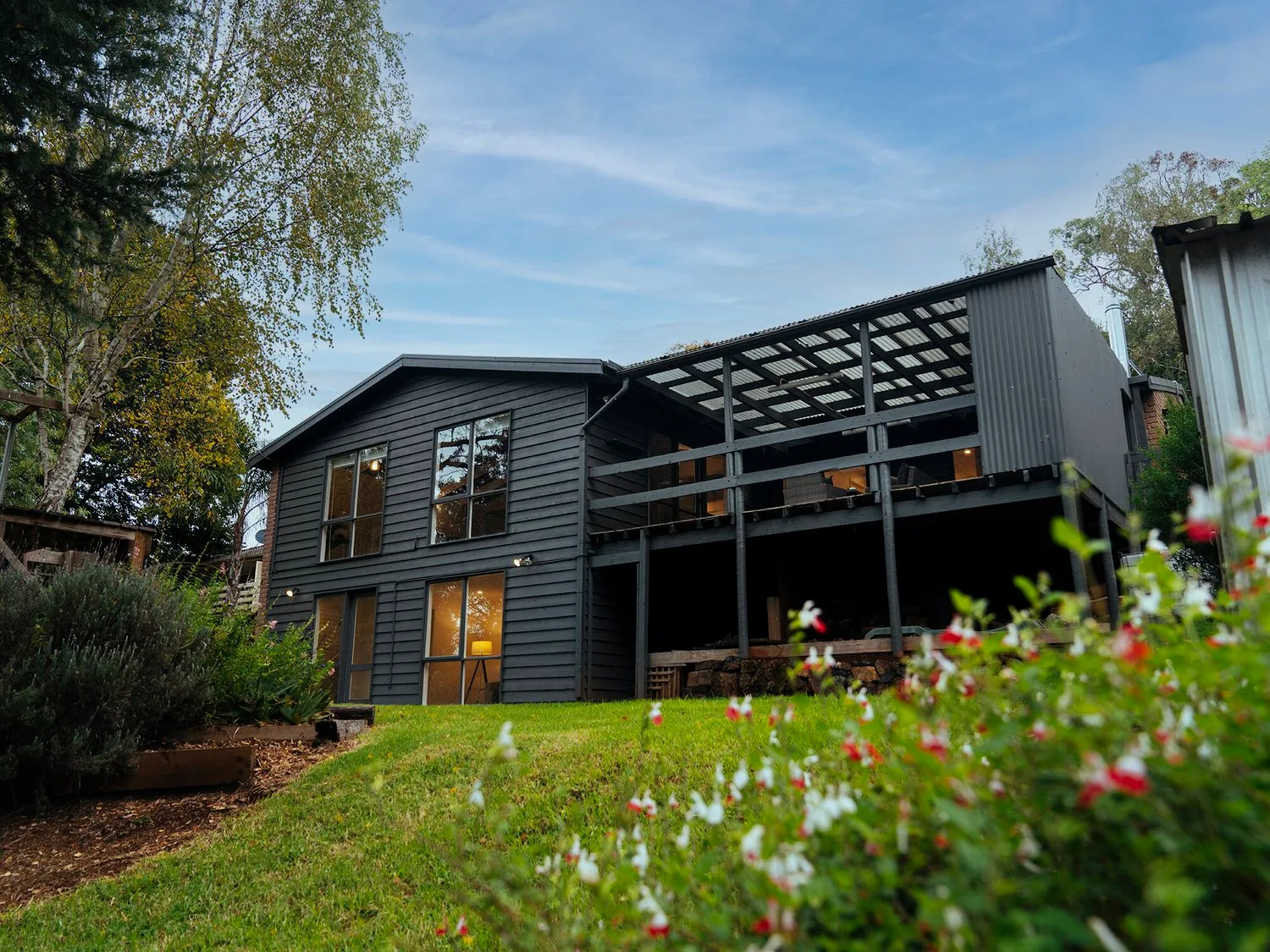Glazing, dark boards and warm-toned exterior elements.