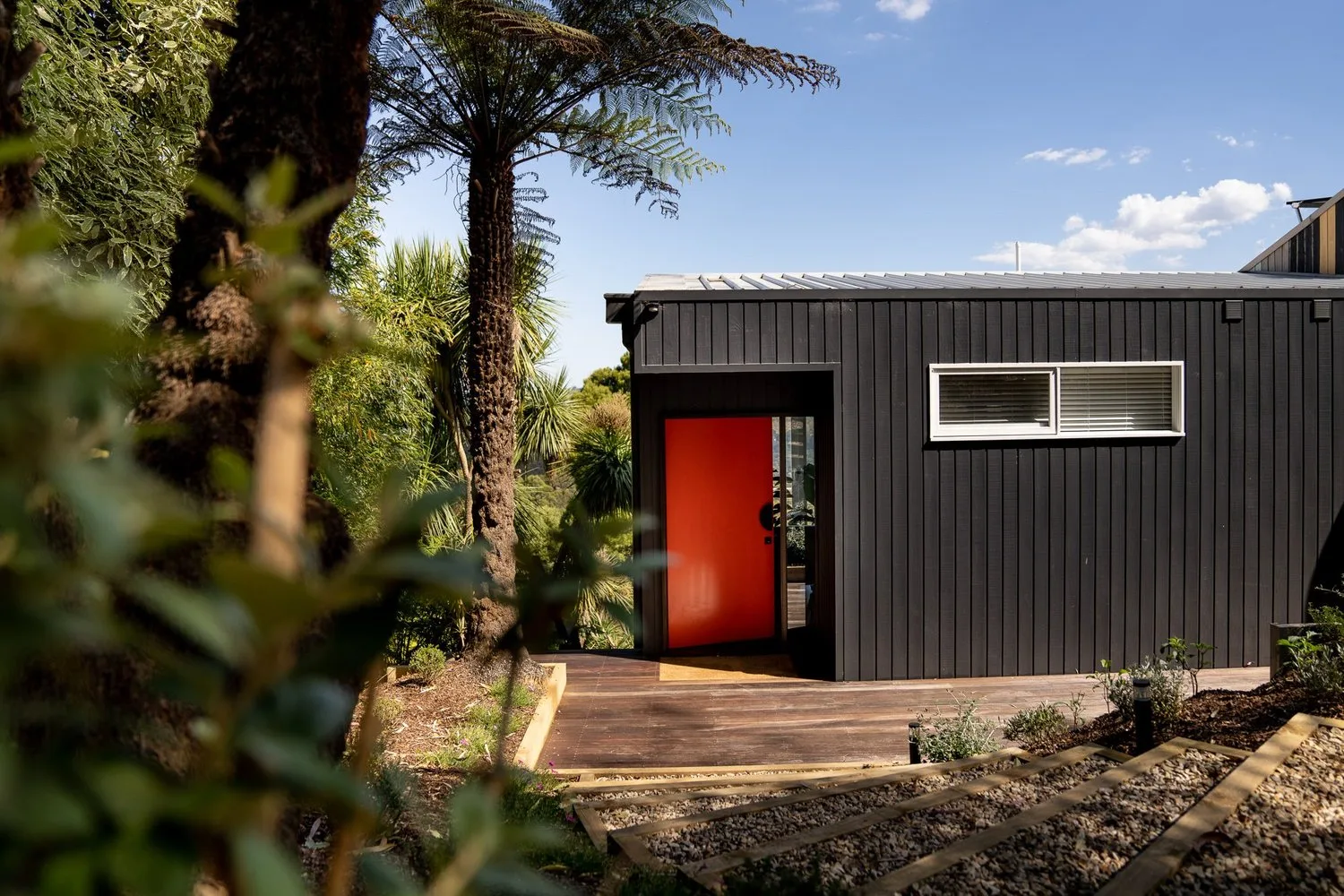 A red door accents the dark exterior.